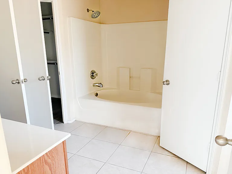 Master bathroom bathtub and shower and the 2clothes closets on each side of the shower/tub