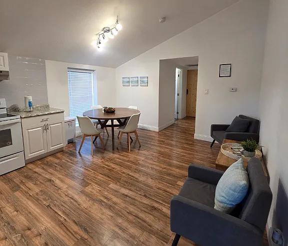 Spacious area featuring a cozy living room, dining space, and nearby kitchen.