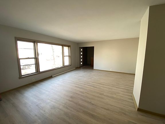 Large living room with big windows for natural light shows off new flooring