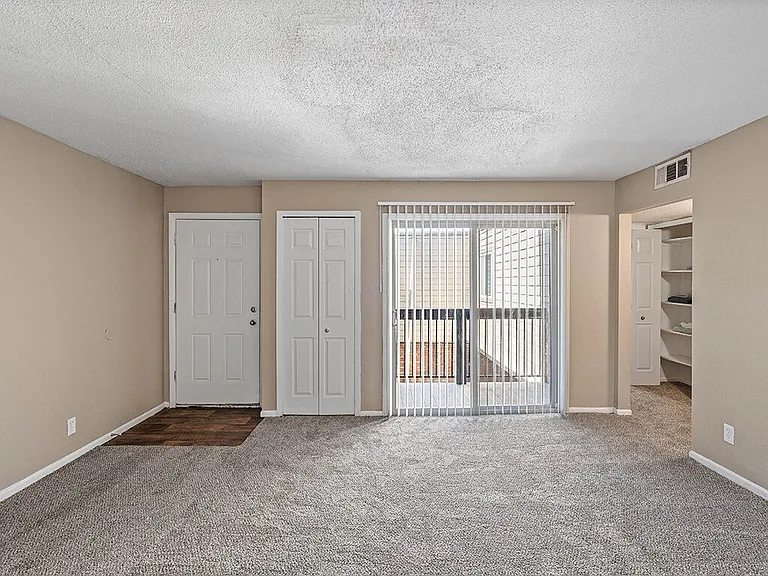 Carpeted Living Room with Balcony