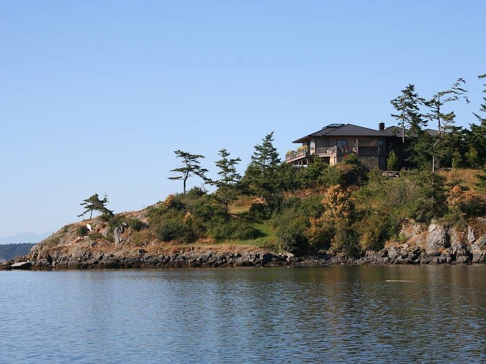 Home sits on a rocky point with water on three sides.