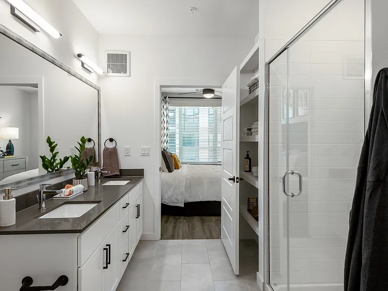 Spacious Bathroom with Double Sinks and Entry to Bedroom