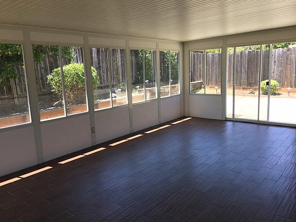 Sunroom with access to BBQ area and both side yards also has