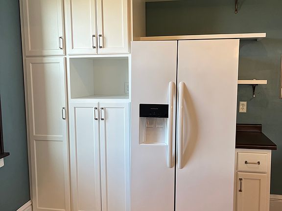 Refrigerator with pantry and broom closet. Cabinetry location for a microwave.