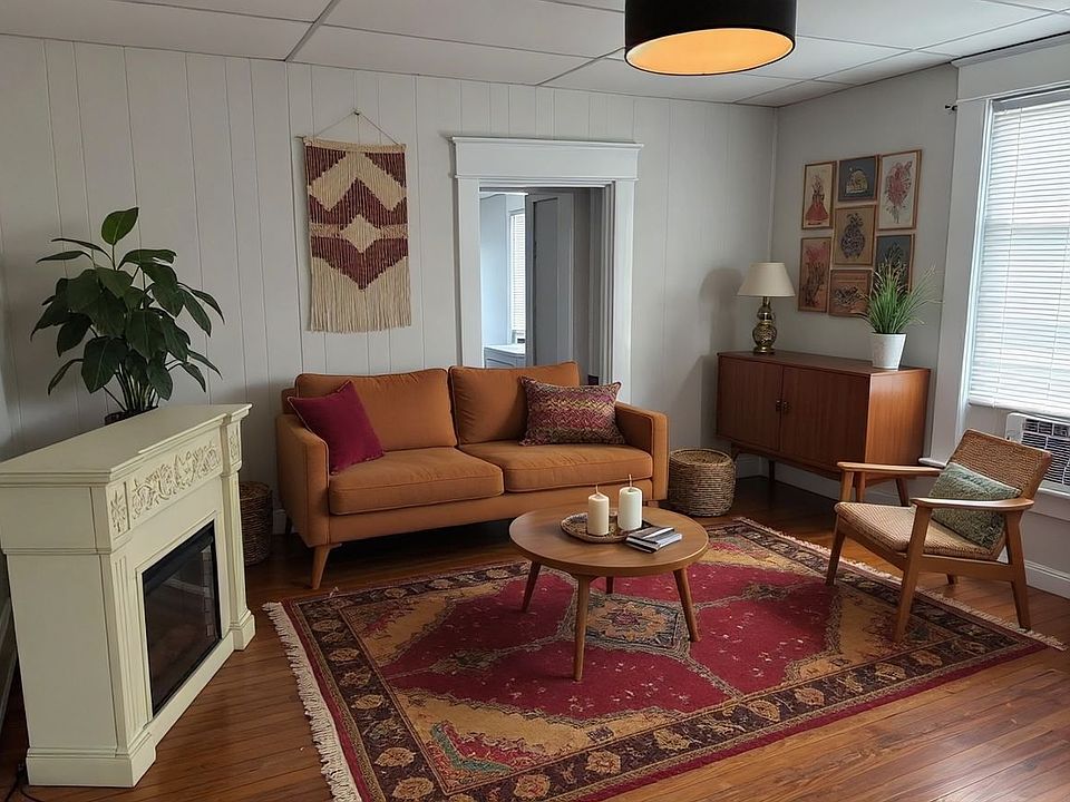 Spacious Living Room with Original Harwood Floors, Designer Lighting and New Sherwin Williams Ammonite Gray Paint Throughout.