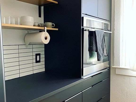 Open shelving, counter nook and wall mounted oven for convenient baking