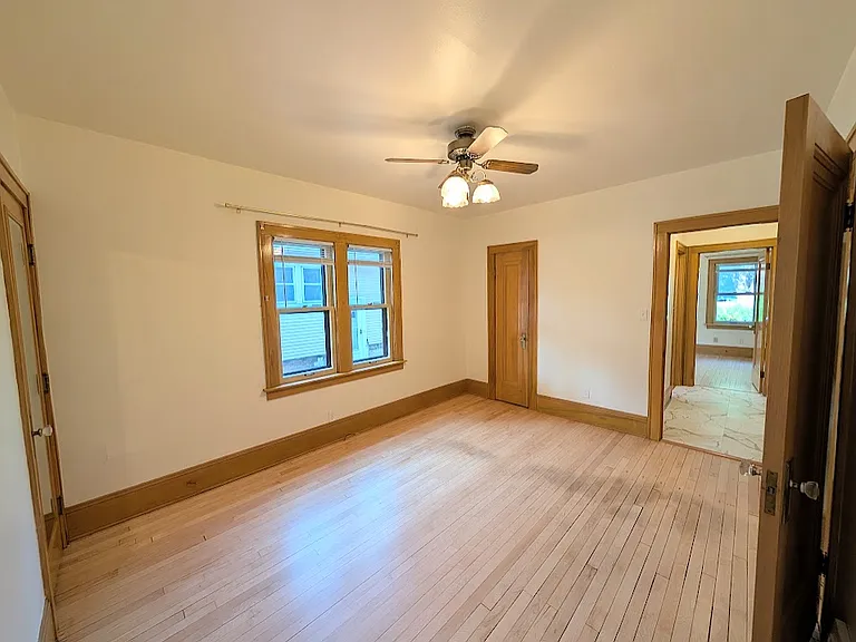 First bedroom with ceiling fan and two closets, one walk-in