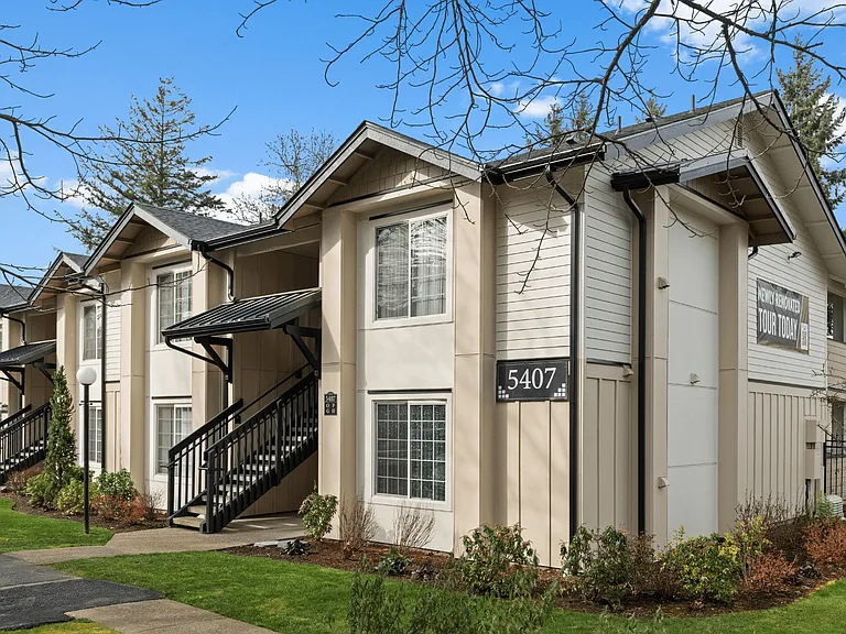 Renovated apartment building exterior at Boardwalk at University Place featuring modern siding, landscaped grounds, and easy access to nearby homes.