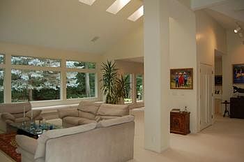 Living room with a cathedral ceiling has skylights, panoramic windows and easy flow into the dining room.  