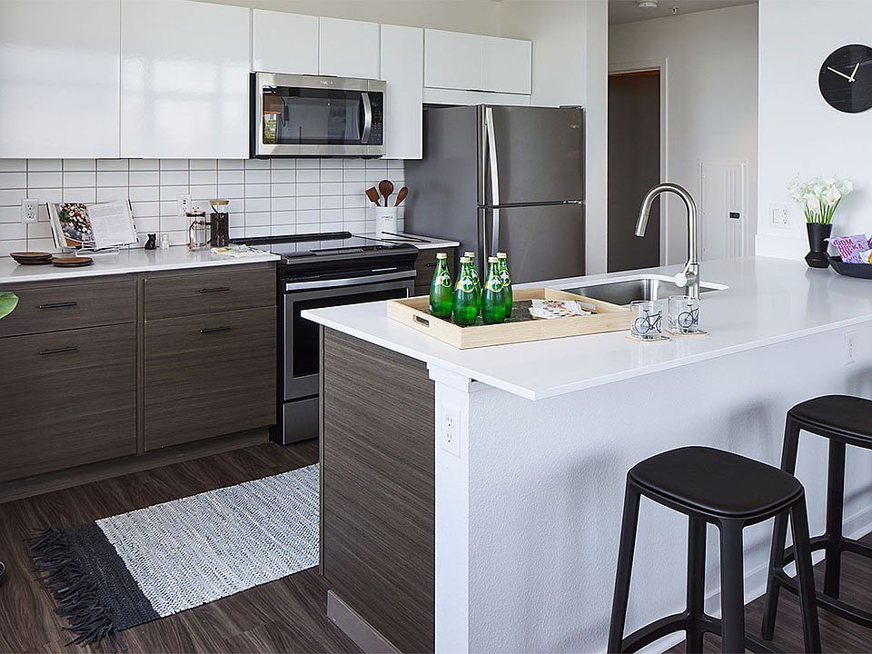 Apartment Kitchen with Stainless Steel Appliances, quartz counters and wood floors.