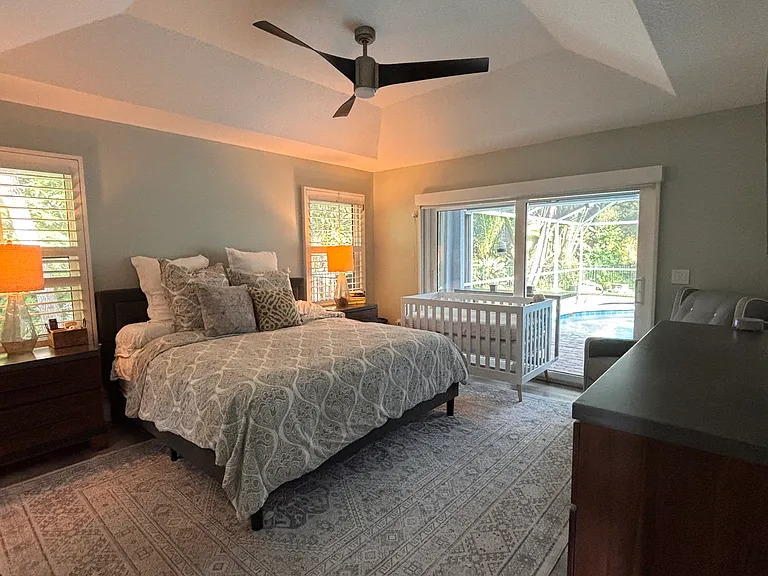 Master bedroom with king size bed, automatic retractible shades for privacy, plantation shutters. 65" TV. (crib no longer in bedroom)