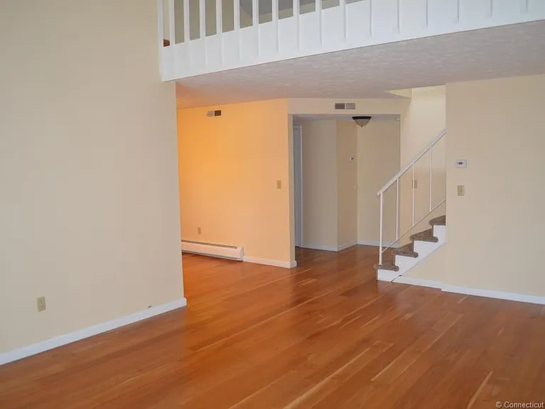 view from the living room to the loft area and dinning room