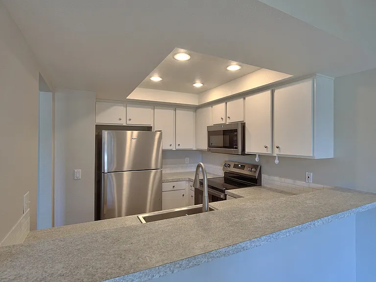 Open kitchen to the dining area and full view of the deck and trees outside.