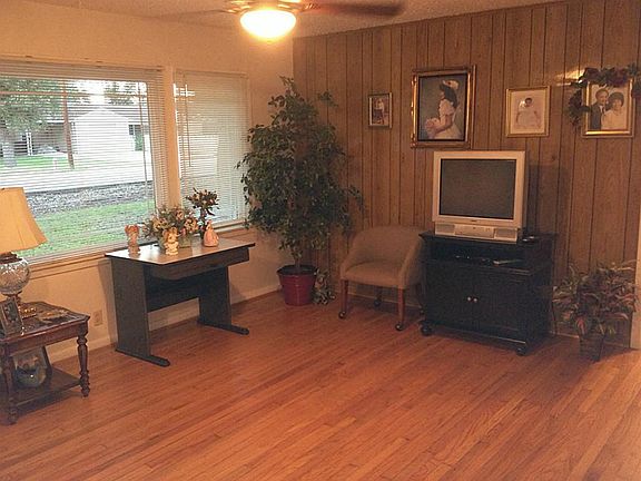 Large, open Den/Living Room with hardwood floors and large windows.