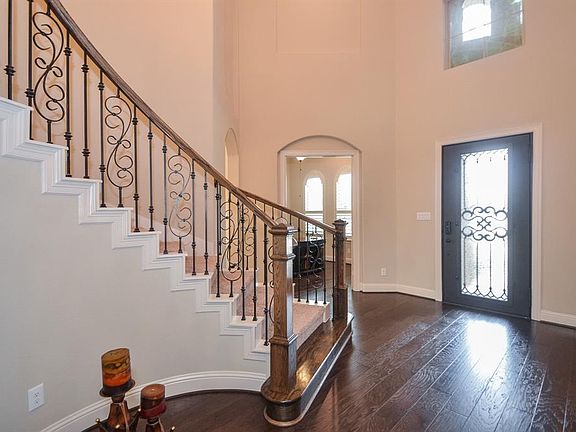The Grand Foyer with two story ceilings. Greet your guest at the welcoming front door with iron details.