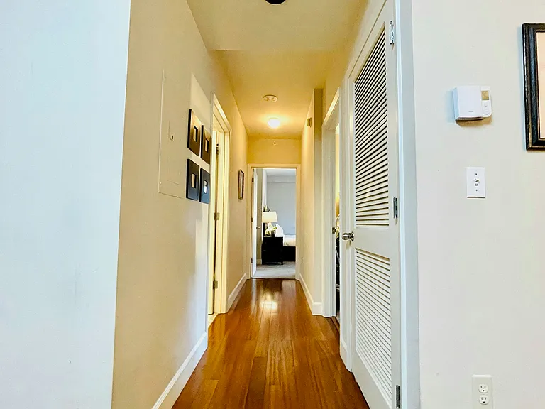 Hallway separating the private bedrooms and the main living, dining, and kitchen areas.