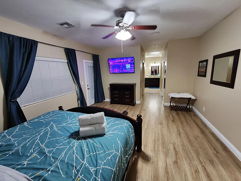 Master Bedroom - television, California King bed, 2 night stands, dresser, bench with storage and ceiling fan.