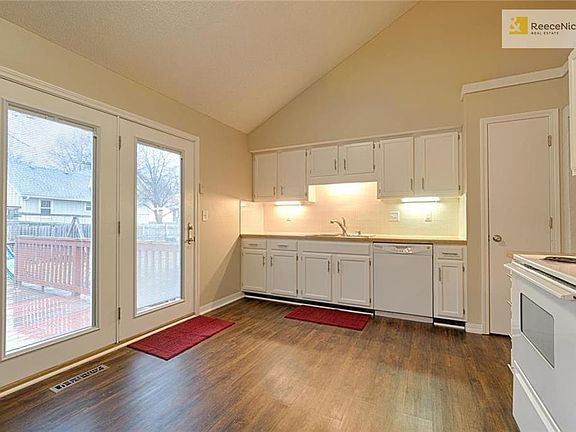 Butcher block counters with under cabinet lighting.  Vaulted, open kitchen. Newer French doors leading to deck.