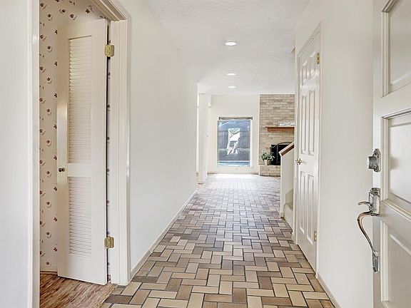 Stepping inside the entry hall you will notice the serene neutral colors. Floor is brick look ceramic tile. The door to the right is a roomy closet under the stairs.