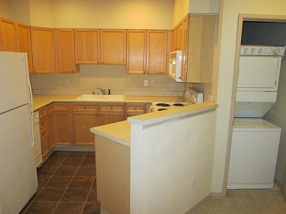 Kitchen with plenty of storage and counter top space! Stacked washer/dryer on the side.