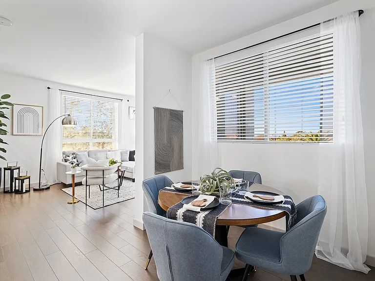 Gather in style at The Grant_where every meal feels special in this airy, light-filled dining nook connected to a welcoming living space.
