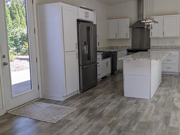 Kitchen with induction range, Frigidaire appliance package, quartz countertops and island eating