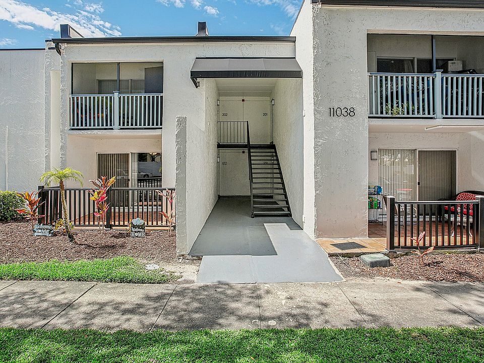 Charming duplex with inviting balconies, sleek modern design, and lush landscaping for serene living.