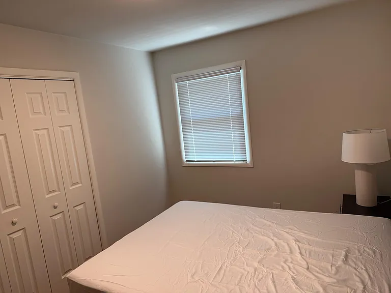Comfortable bedroom featuring a closet, a window with blinds for light control, and space for a full/queen bed.
