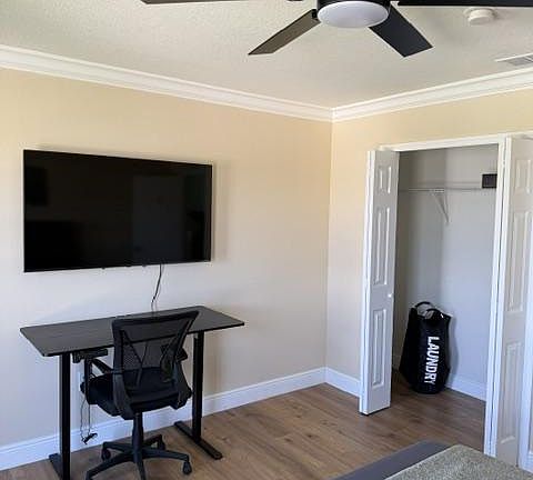 electric standing desk, ergonomic chair and 55" smart TV & closet w/ portable laundry bag