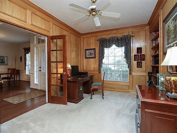 This cozy, block-paneled study has a set of built in bookcases and plenty of room to set up your home office or library.