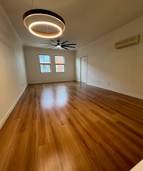 Large living area wiuth custome light fixture with wood trim and huge big ass fan near the windows overlooking Lewis street