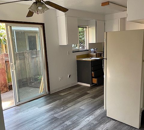 inside dining area to left and then kitchen and fenced in backyard