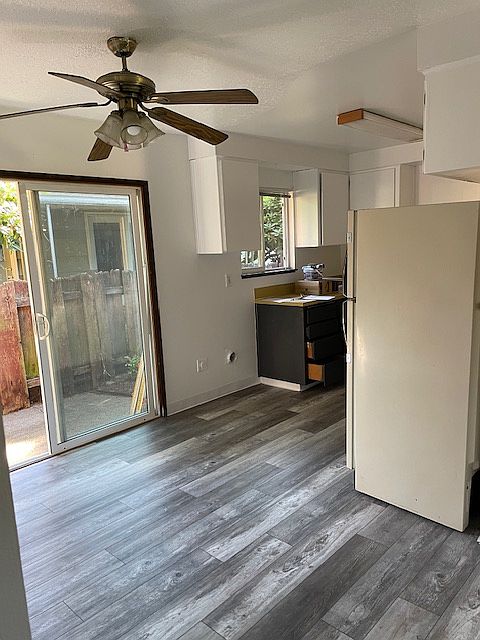 inside dining area to left and then kitchen and fenced in backyard