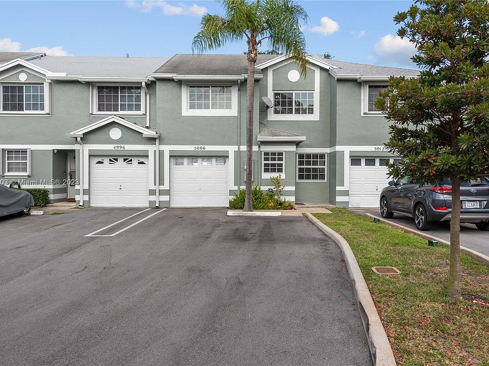 Front exterior of townhome with extended double driveway that can easily accommodate 4 cars.