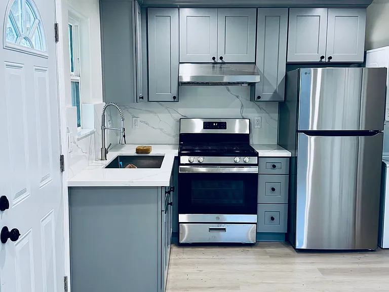 Modern open concept kitchen with brand new stainless steel appliances - Stove, oven, fridge, and stylish finishes.