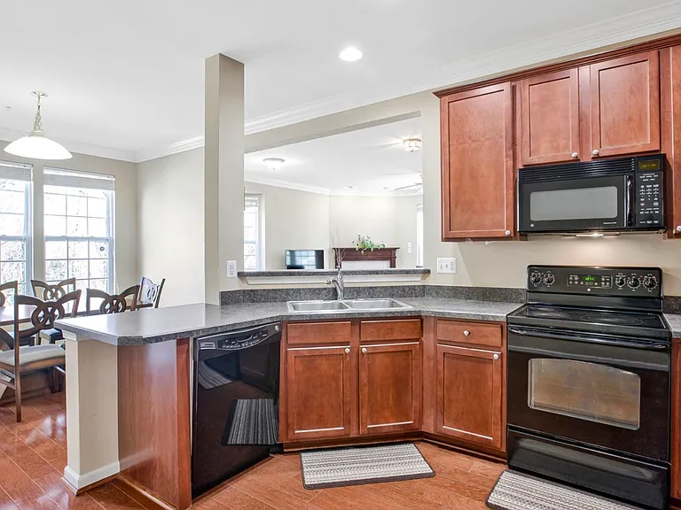 Warm wood cabinetry, granite countertops, and stainless steel appliances come together to create a kitchen that feels both timeless and beautifully functional.