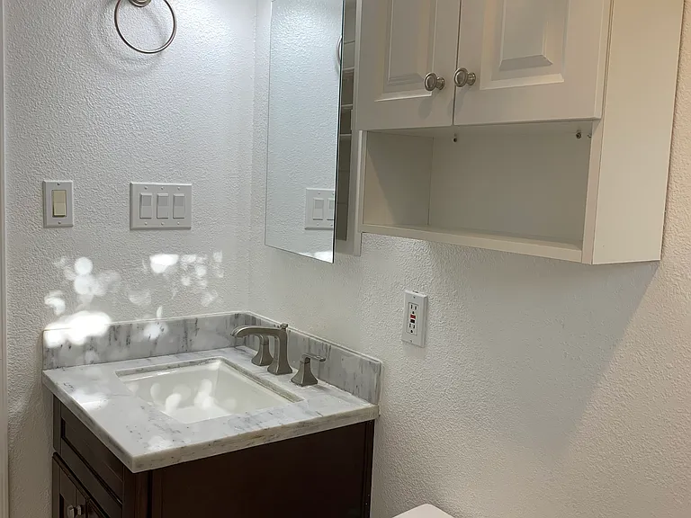 Hallway bathroom featuring a water-efficient one-piece toilet