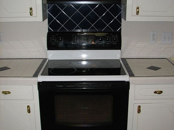 Kitchen with laminate floors and tiled counters