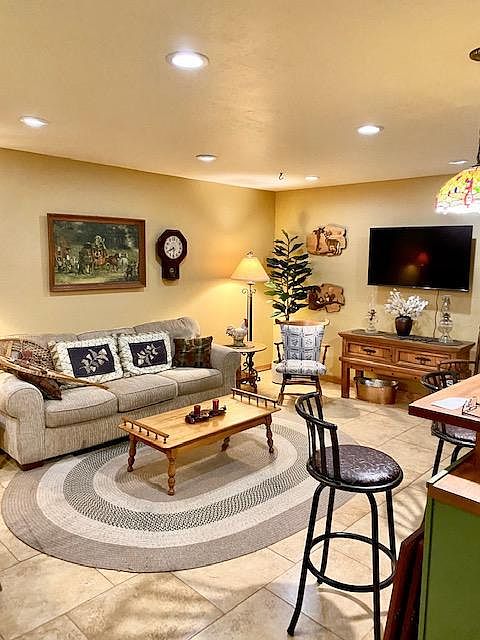 living room. different rug different art. Its a beautiful sunny room in the afternoon and looks out to side yard and grassed front yard