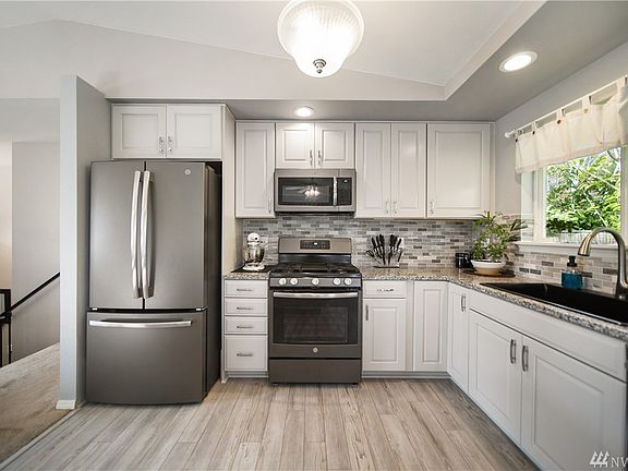 New cabinetry with tile backsplash and overmount sink. 