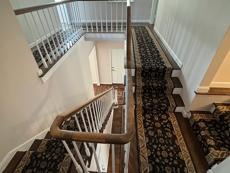 Stairs from second floor showing doors to front two bedrooms (+3 stairs at right to bathroom).