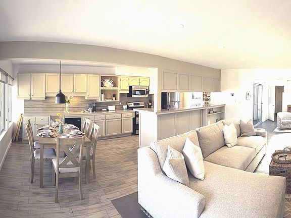 Panoramic of entry stairs, living room, dining area and kitchen