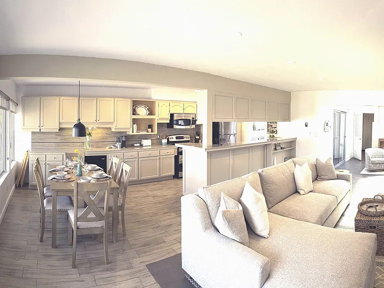 Panoramic of entry stairs, living room, dining area and kitchen