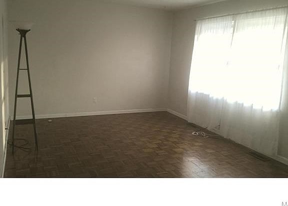Living room has wood parquet floor and large window that brings in the light!