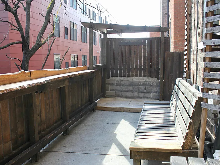 Large patio with wooden bench and bar top.