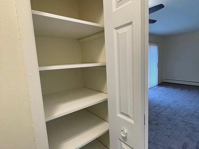 Large linen closet has brand new easy clean shelving and new door.