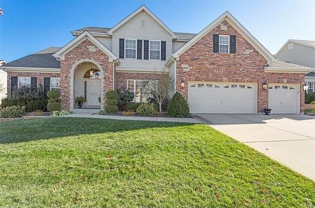 Lovely brick and stone elevation.  Concrete driveway.