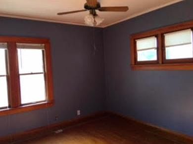 Smaller bedroom with wood floor.