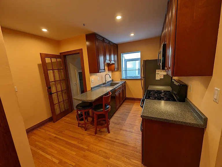 Kitchen looking east and door to basement in northeast corner. Side outside door is not seen in picture.