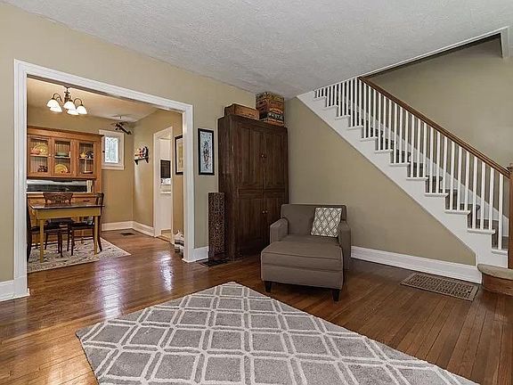Living room looking into dining room and stairs going up to bedrooms and bath